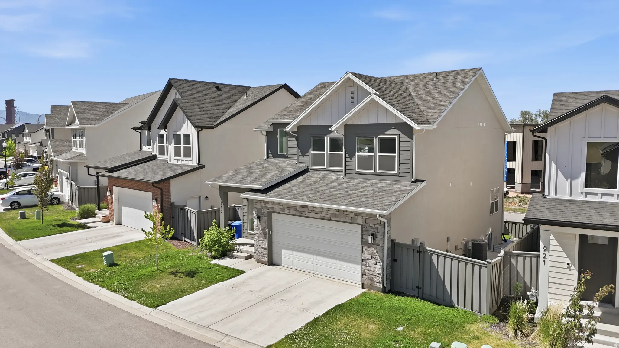 Contemporary two-story residence featuring a gray and white exterior with stone accents