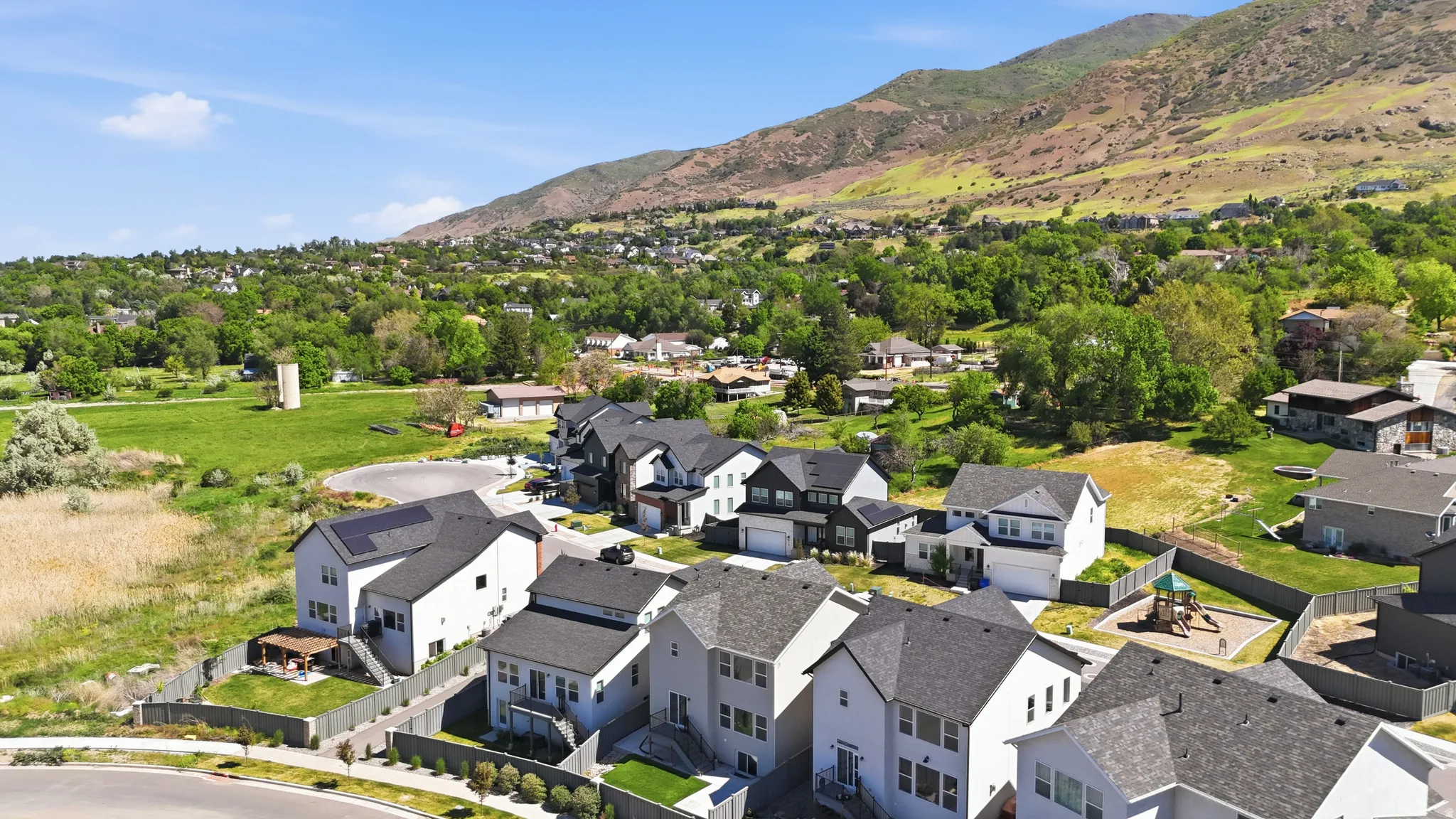 Residential community with modern two-story homes featuring dark shingle roofs and light-toned siding