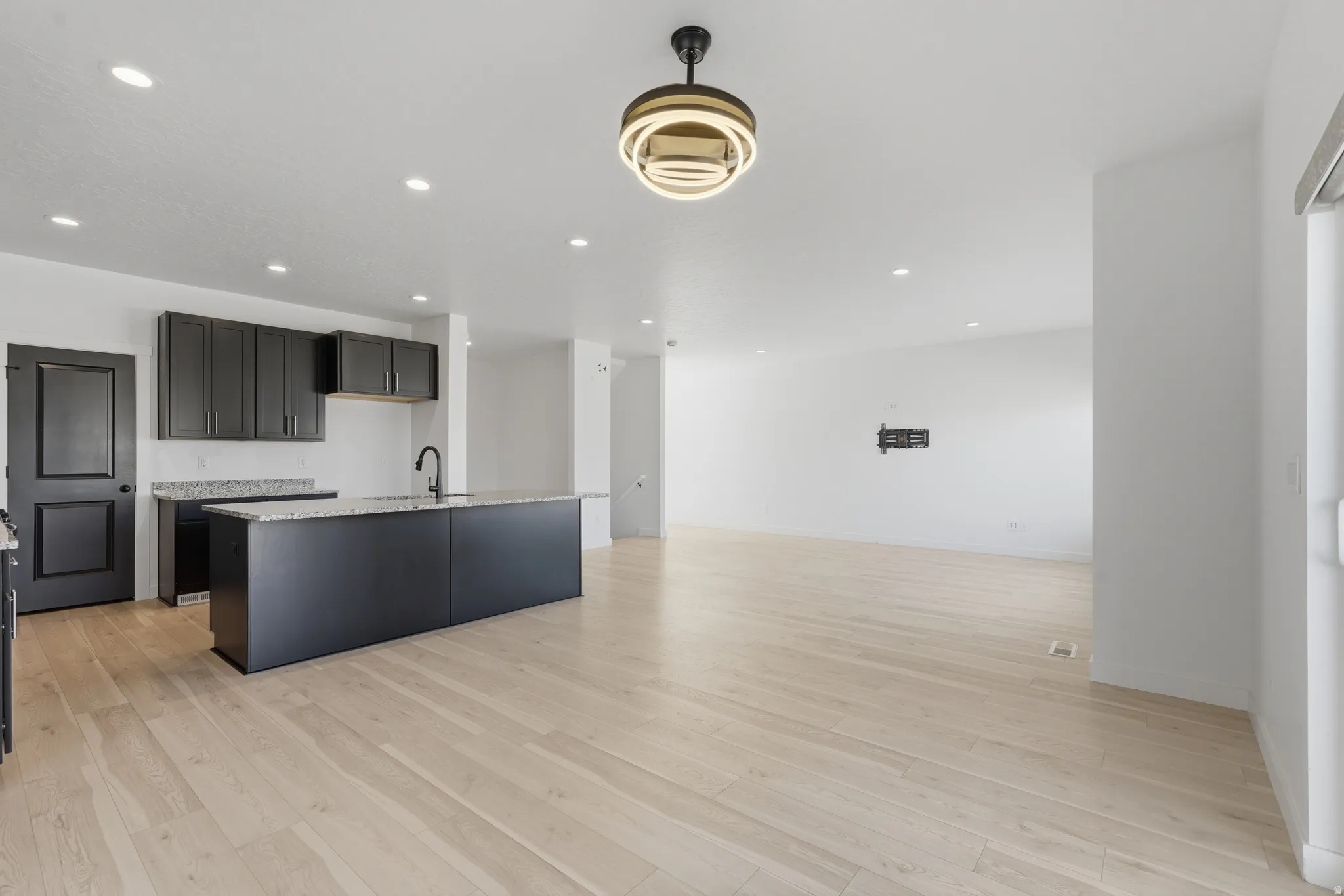 Open concept living space featuring light wood-finish flooring, recessed lighting, and a modern ceiling fixture