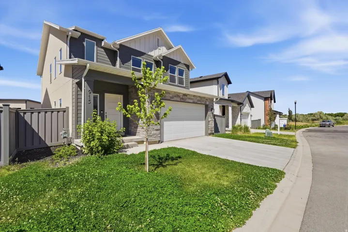 Contemporary two-story exterior with a two-car garage, stone and siding accents, and a concrete driveway
