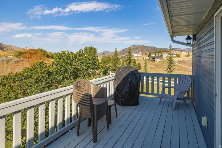 Expansive exterior deck featuring a sturdy railing, blue siding, and an outdoor light fixture