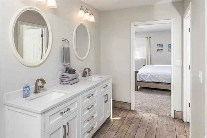 Double vanity featuring white cabinetry, integrated sinks, and brushed nickel fixtures