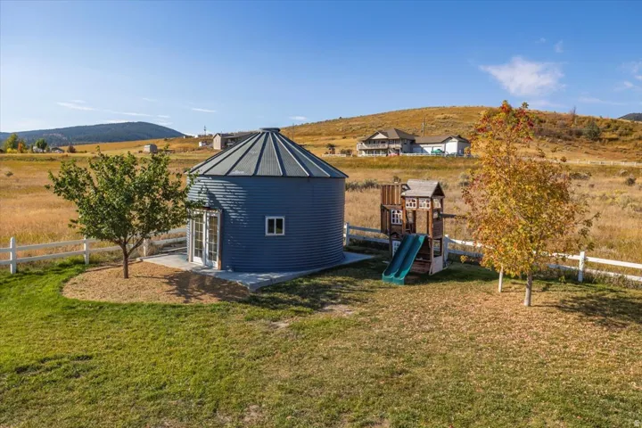 Blue corrugated metal outbuilding with a conical roof and a concrete patio