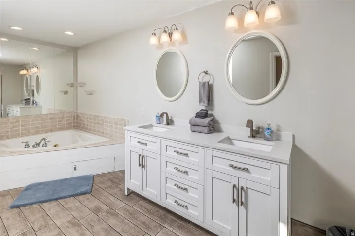 Dual vanity with undermount sinks, white cabinetry, and brushed nickel hardware