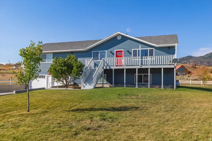 Two-story residence featuring blue siding and a prominent deck with white railings