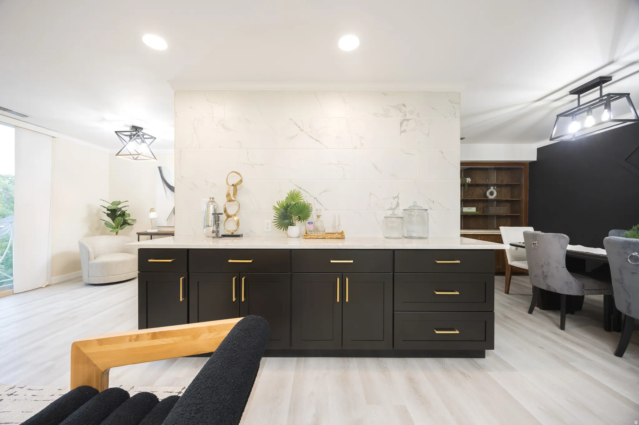 Central island with dark wood-finish cabinetry, gold-tone hardware, and a light-toned countertop