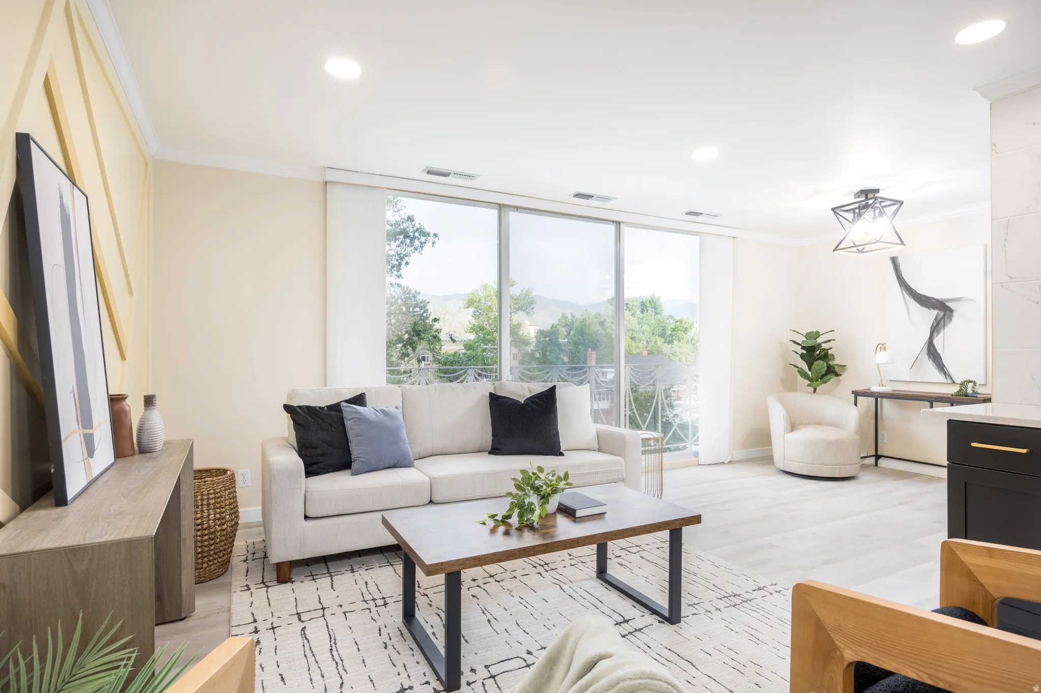 Open-concept living space featuring expansive glass doors, wood-finish flooring, recessed lighting, and a contemporary ceiling fixture