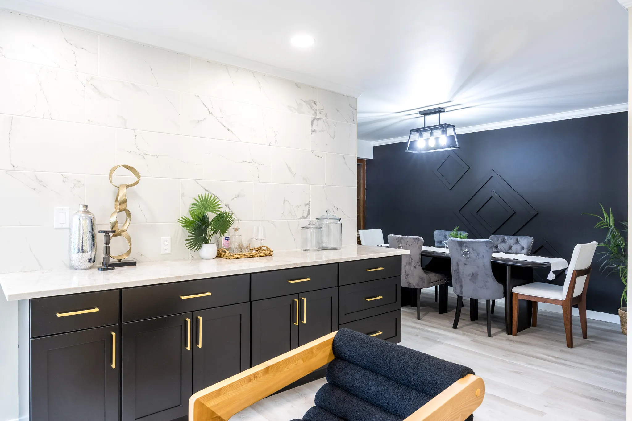 Built-in cabinetry with gold-toned hardware, white countertop, and a full-height tiled backsplash