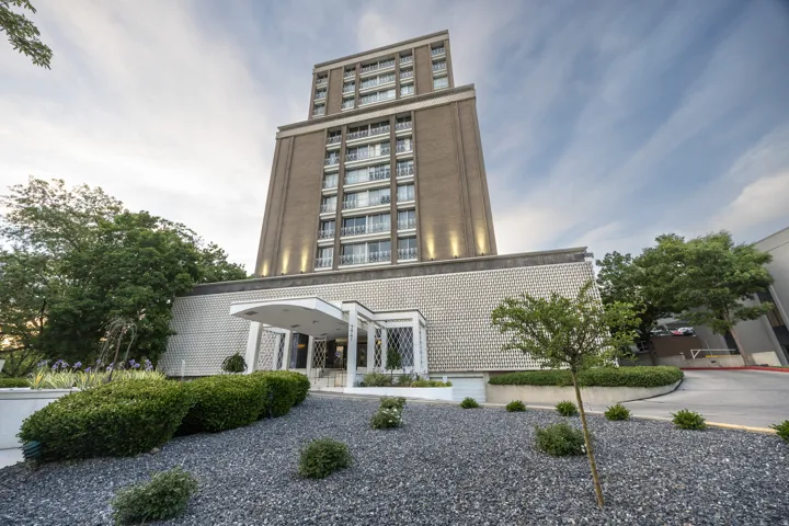 Mid-rise residential building featuring a brick facade with multiple balconies