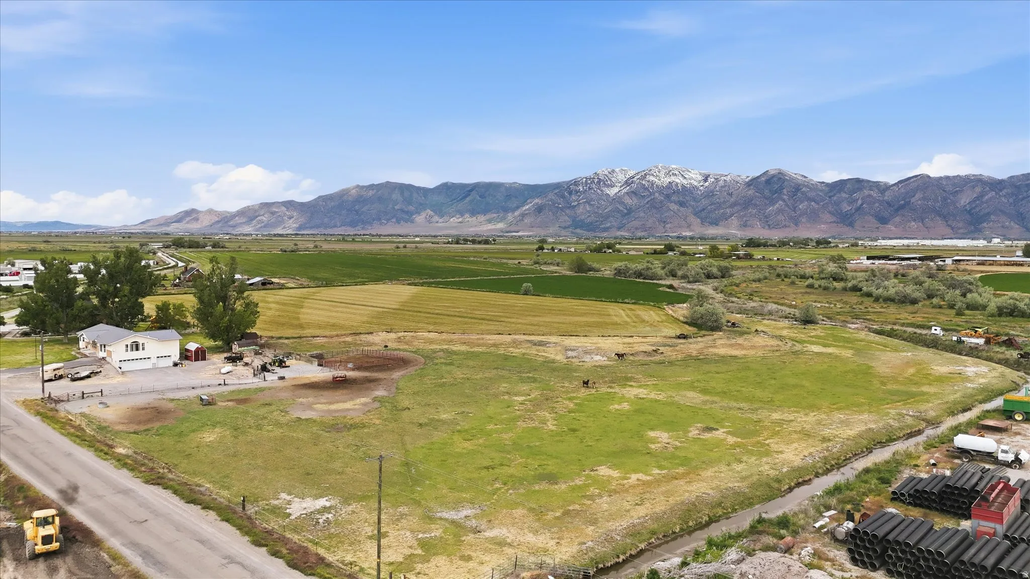 Expansive rural property featuring a single-story residence with an attached two-car garage