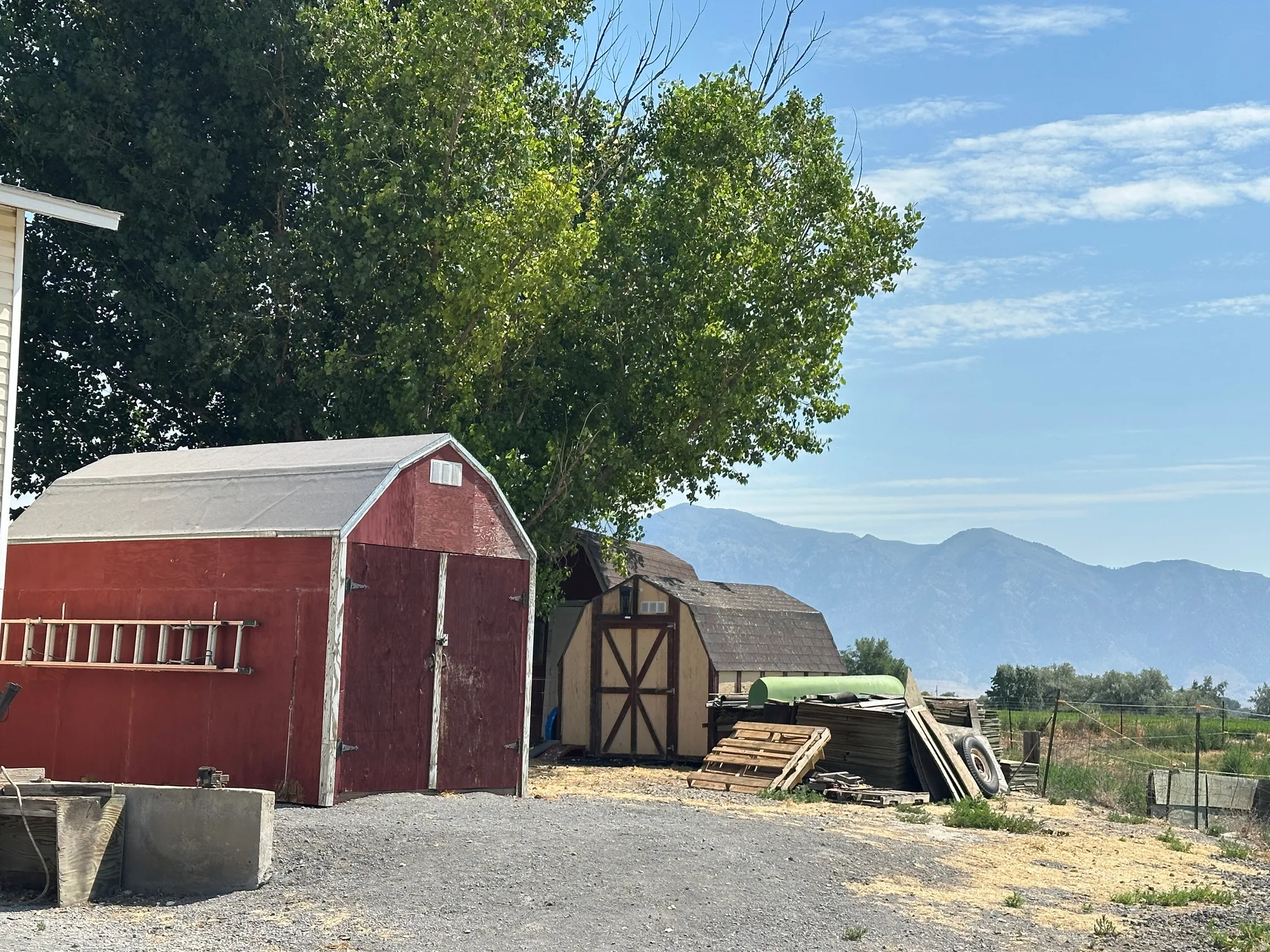 Red barn-style shed with a gambrel roof and double doors