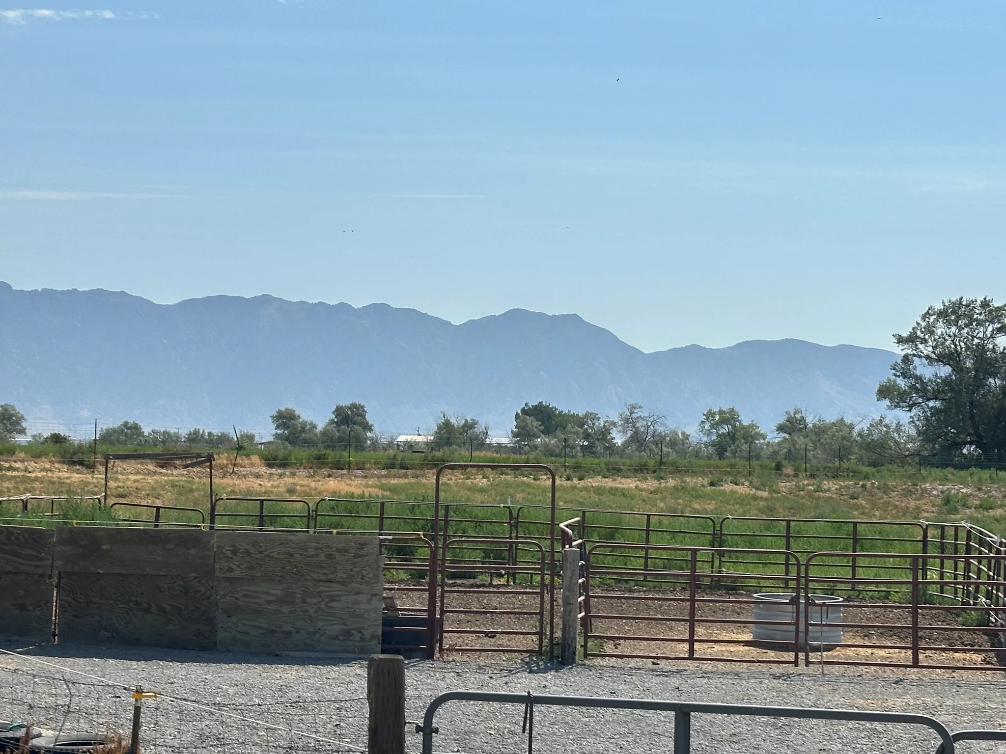 Expansive outdoor space featuring metal corrals and a gravel ground cover