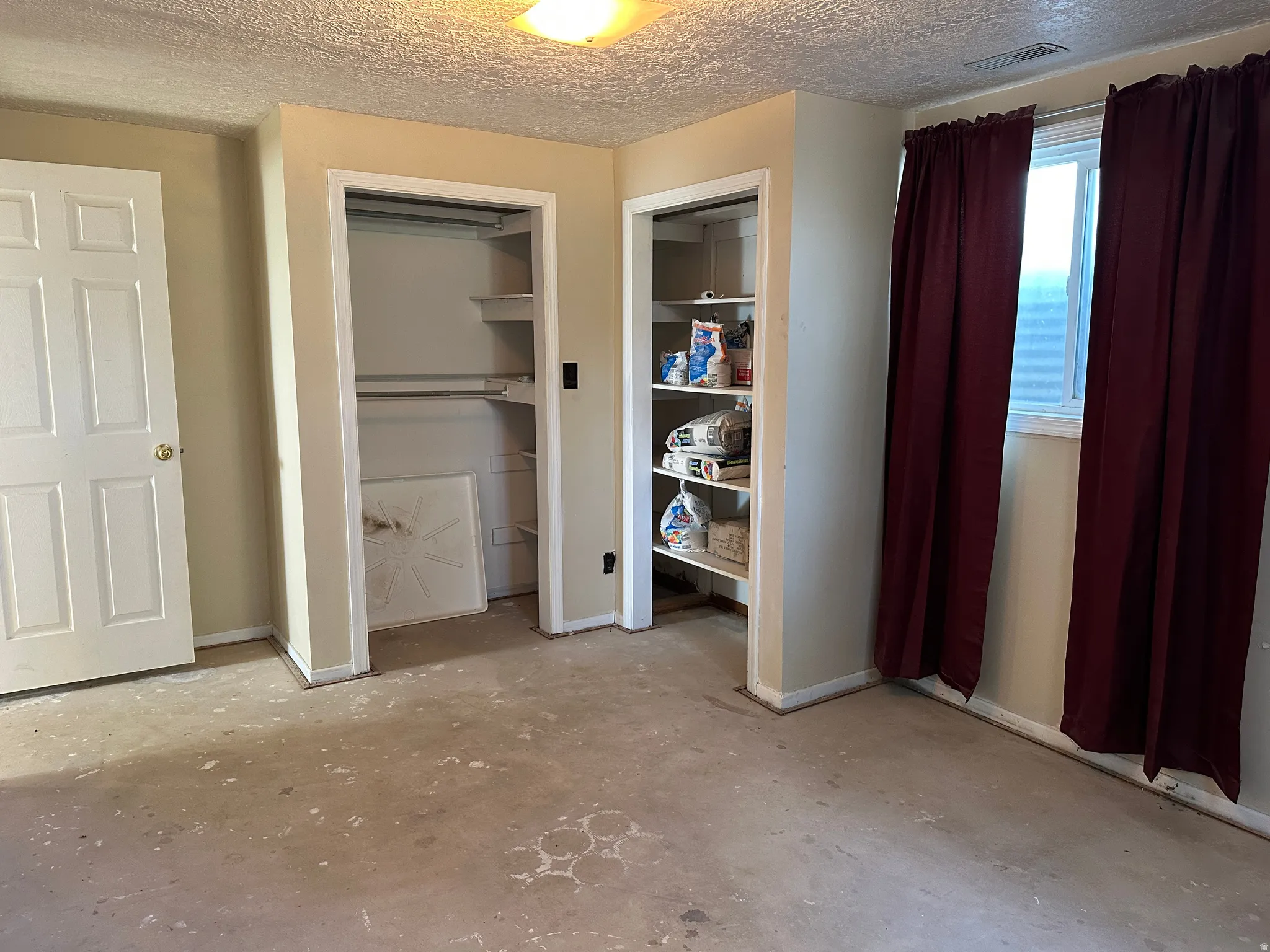 Interior room featuring two closet spaces, one with built-in shelving