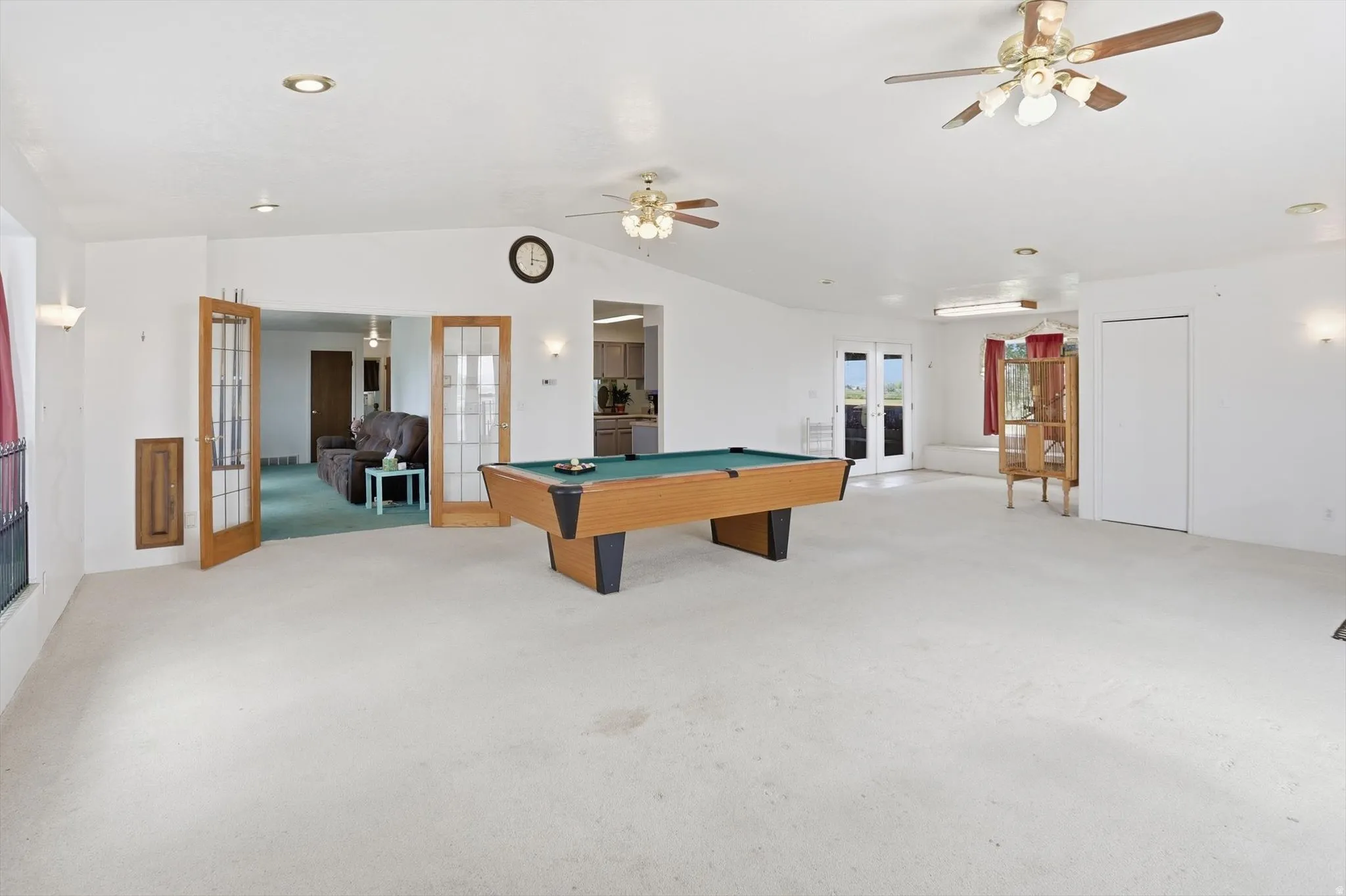 Expansive room featuring light-toned carpeting and white walls
