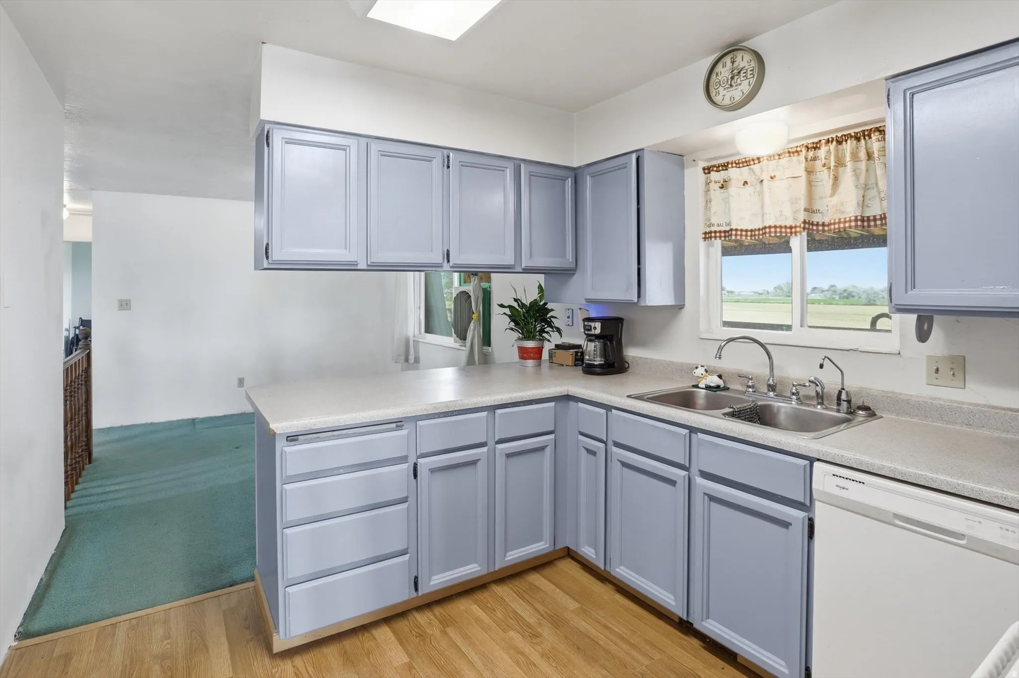 Kitchen featuring light blue cabinetry and light-toned countertops