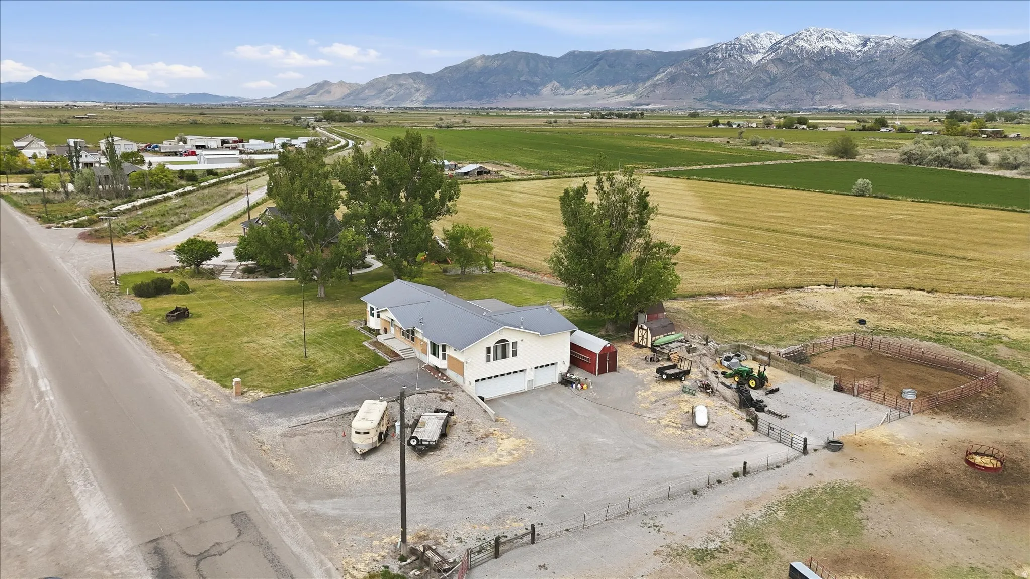 Single-story residence featuring a three-car garage, surrounding green space, and mountain scenery