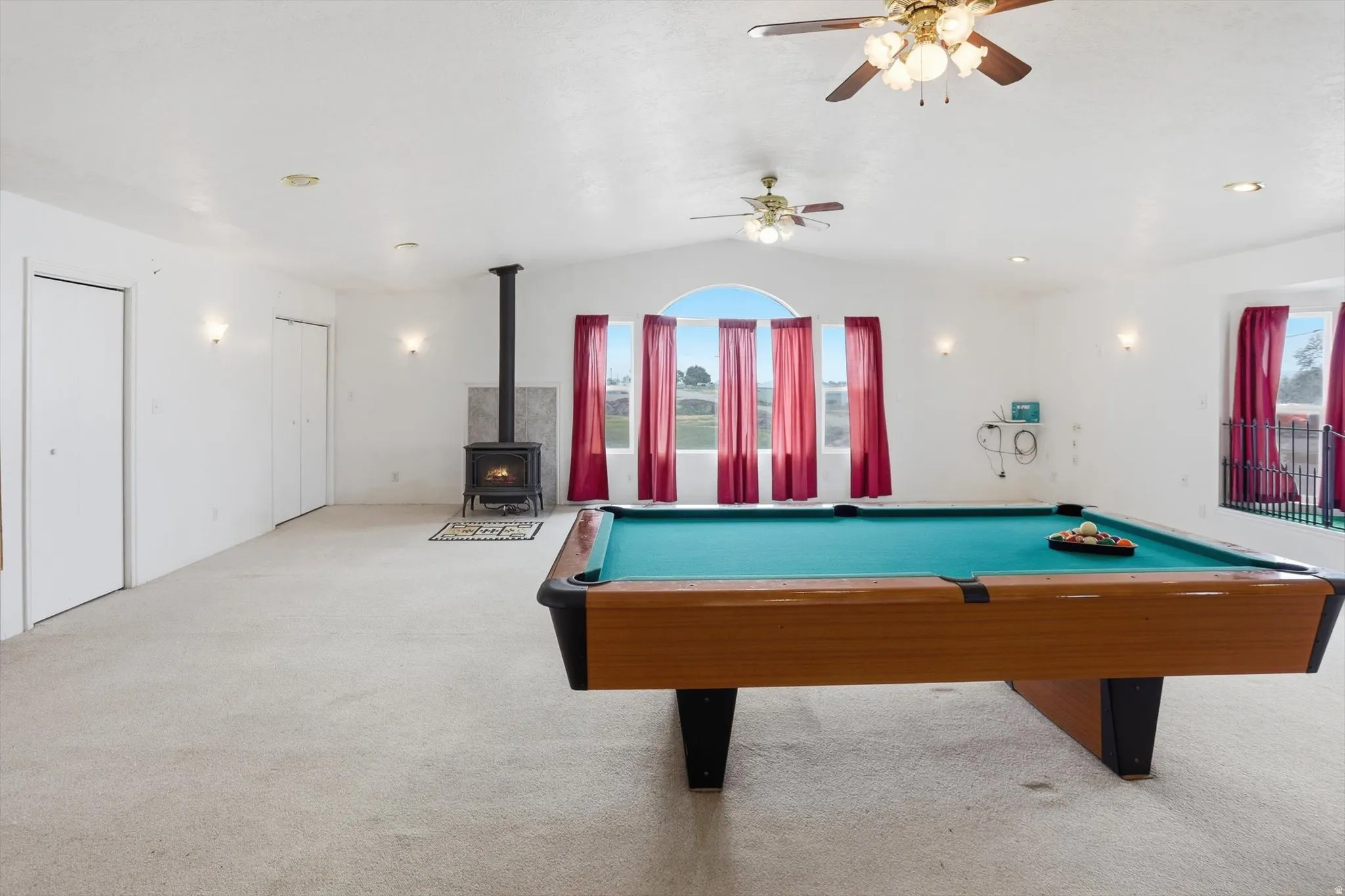 Spacious room featuring vaulted ceilings, recessed lighting, and ceiling fans