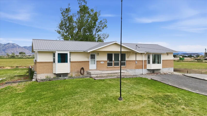 Ranch-style exterior with a metal roof and light-colored siding