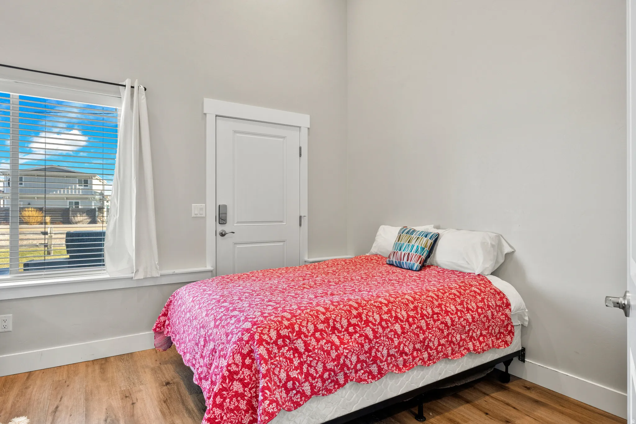 Room featuring wood-finish flooring, white baseboards, and light gray walls