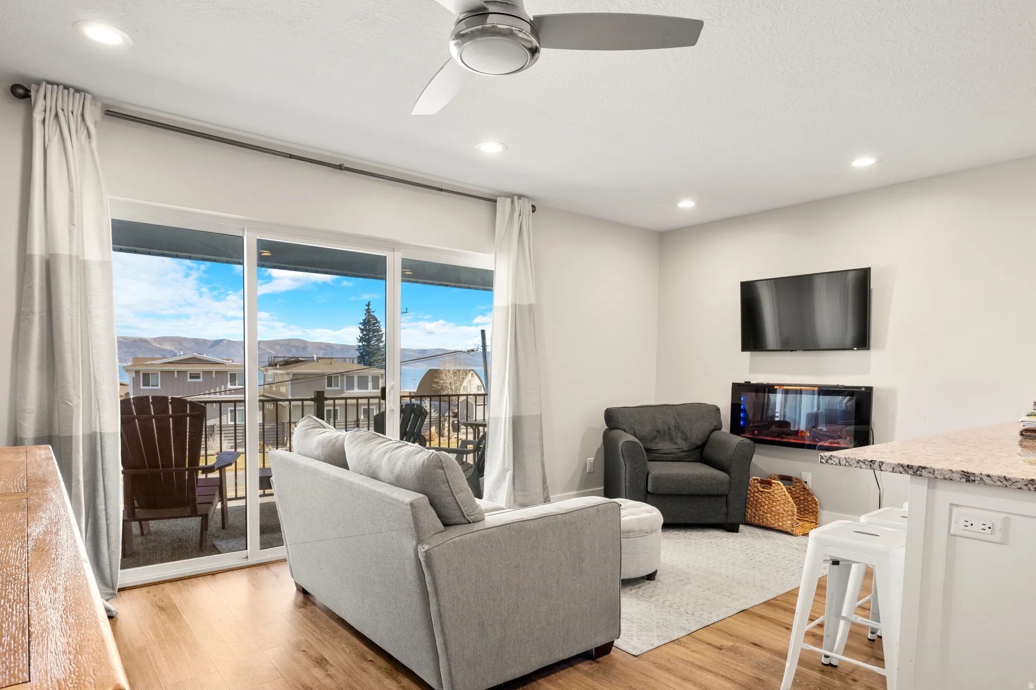 Bright living area with wood-finish flooring, recessed lighting, and a ceiling fan