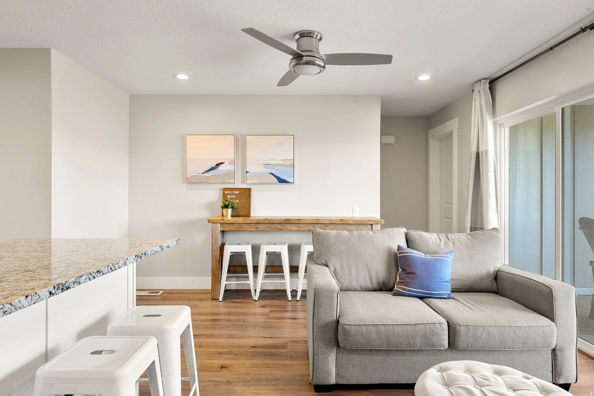 Open-concept living area featuring wood-finish flooring, recessed lighting, and a ceiling fan
