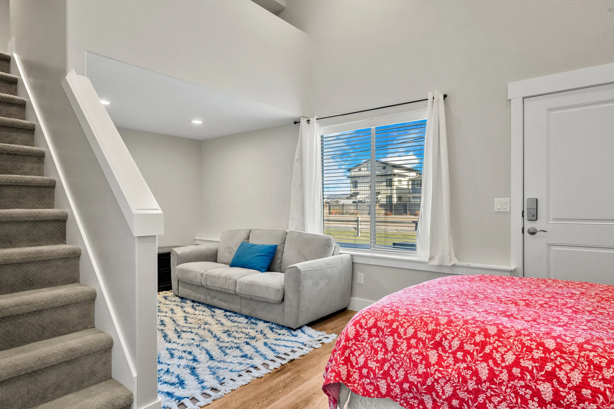 Carpeted staircase with white railing, recessed lighting, and wood-finish flooring