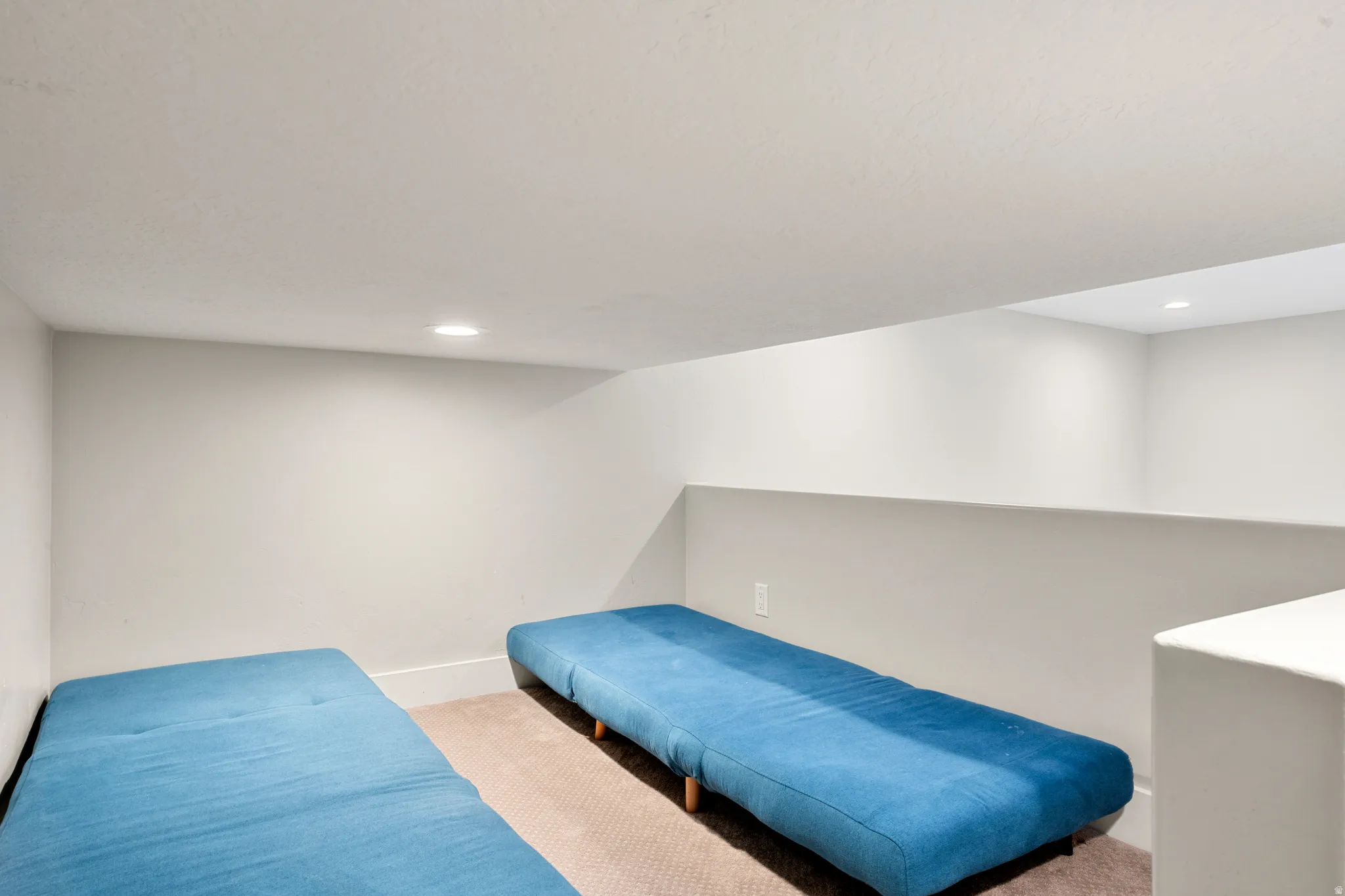 Carpeted room featuring recessed lighting and a partial wall partition