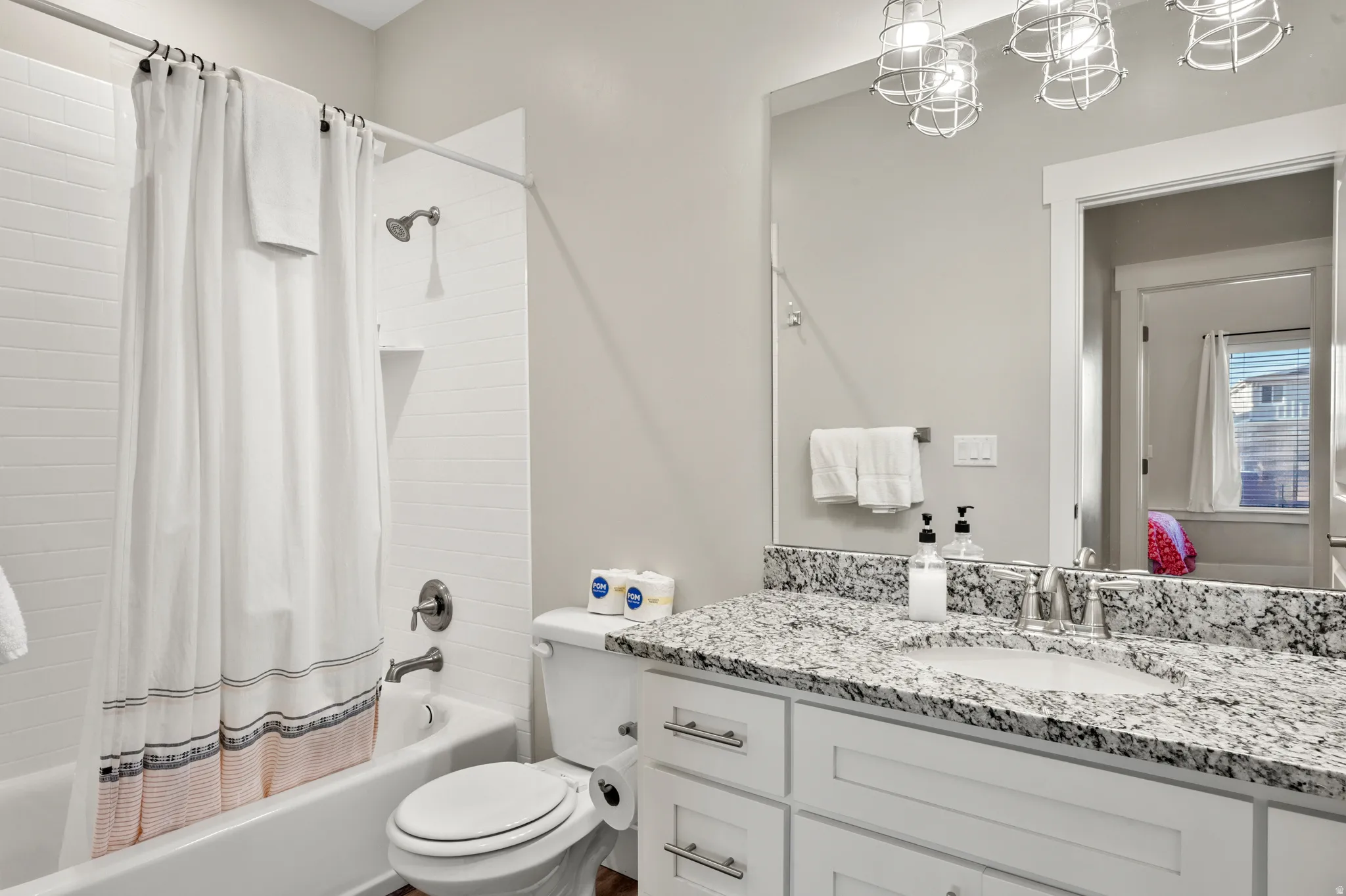 Bathroom featuring a full vanity with granite countertop, undermount sink, and chrome fixtures