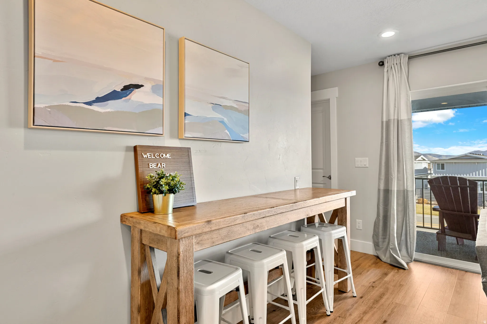 Dining area featuring wood-finish flooring, a built-in bar-height table, recessed lighting, and direct access to an outdoor balcony