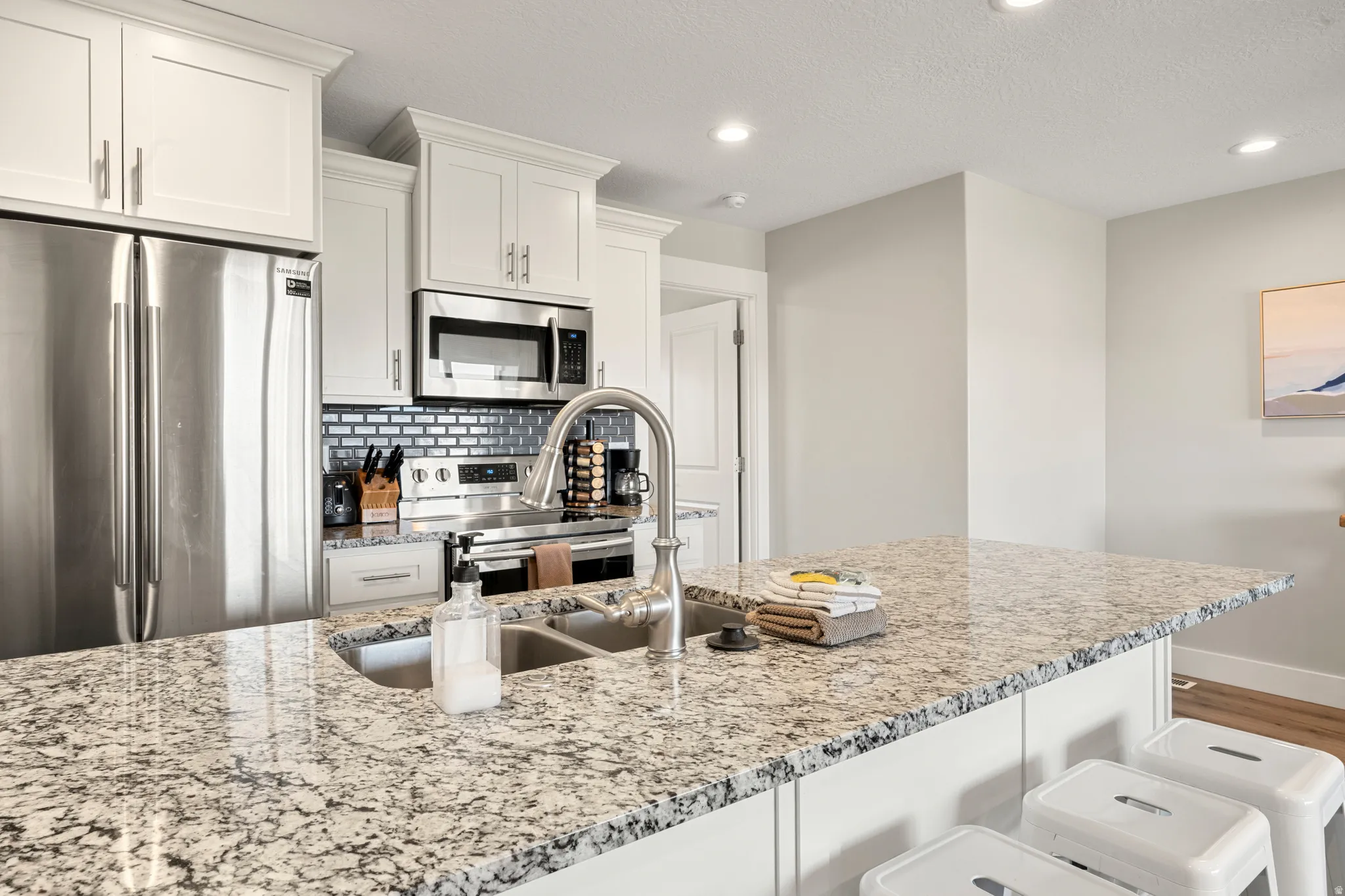 Kitchen featuring a granite island with an undermount sink and gooseneck faucet