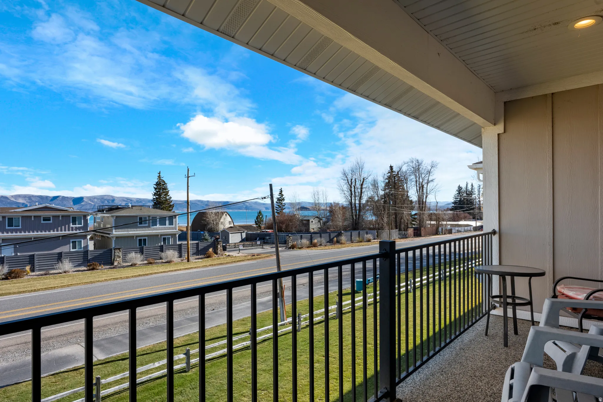 Covered balcony featuring a black metal railing and a textured concrete surface