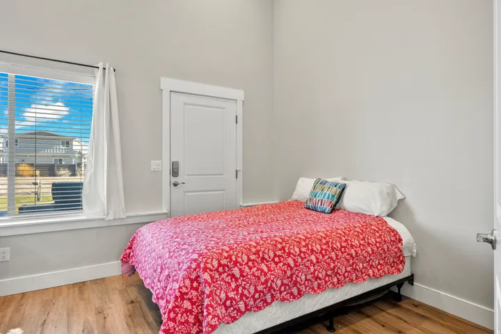 Room featuring wood-finish flooring, white baseboards, and light gray walls