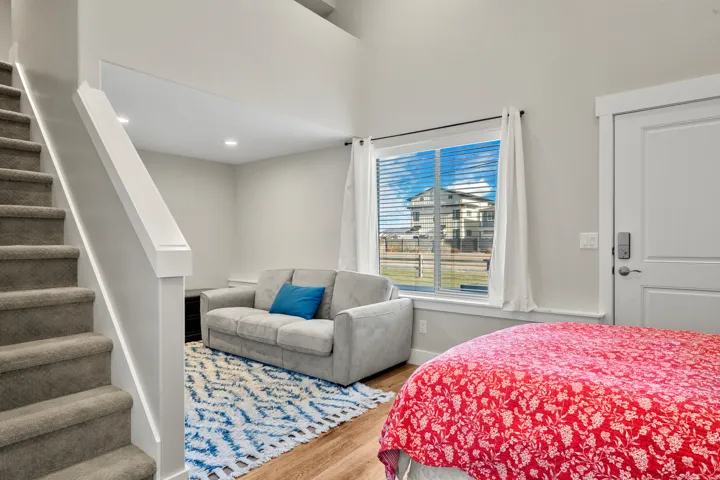 Carpeted staircase with white railing, recessed lighting, and wood-finish flooring