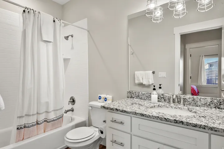 Bathroom featuring a full vanity with granite countertop, undermount sink, and chrome fixtures