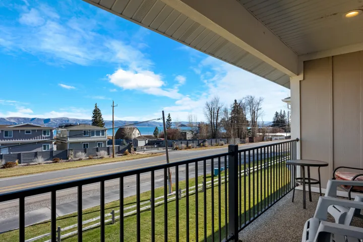 Covered balcony featuring a black metal railing and a textured concrete surface