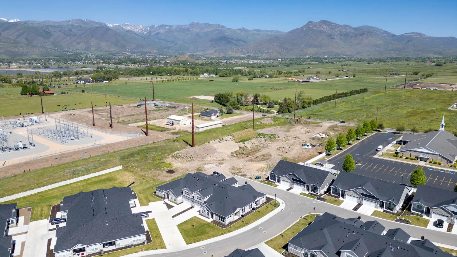 Newly constructed residential development featuring uniform dark gray roofing and light-colored exteriors