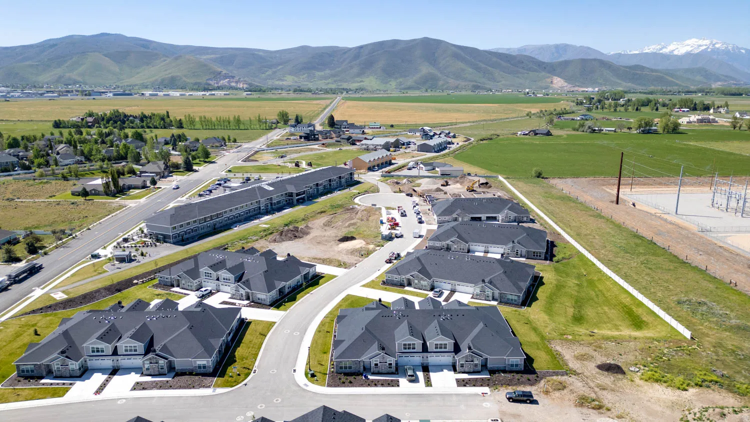 Newly constructed townhomes and multifamily buildings with dark grey roofing and light grey siding