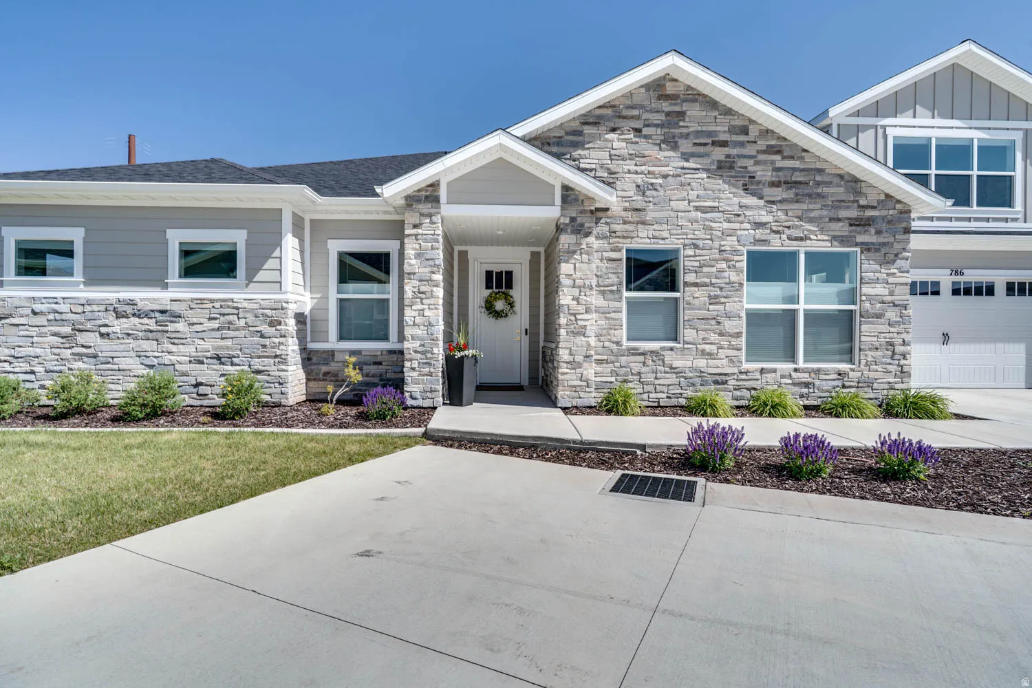 Contemporary facade featuring stone veneer and horizontal siding