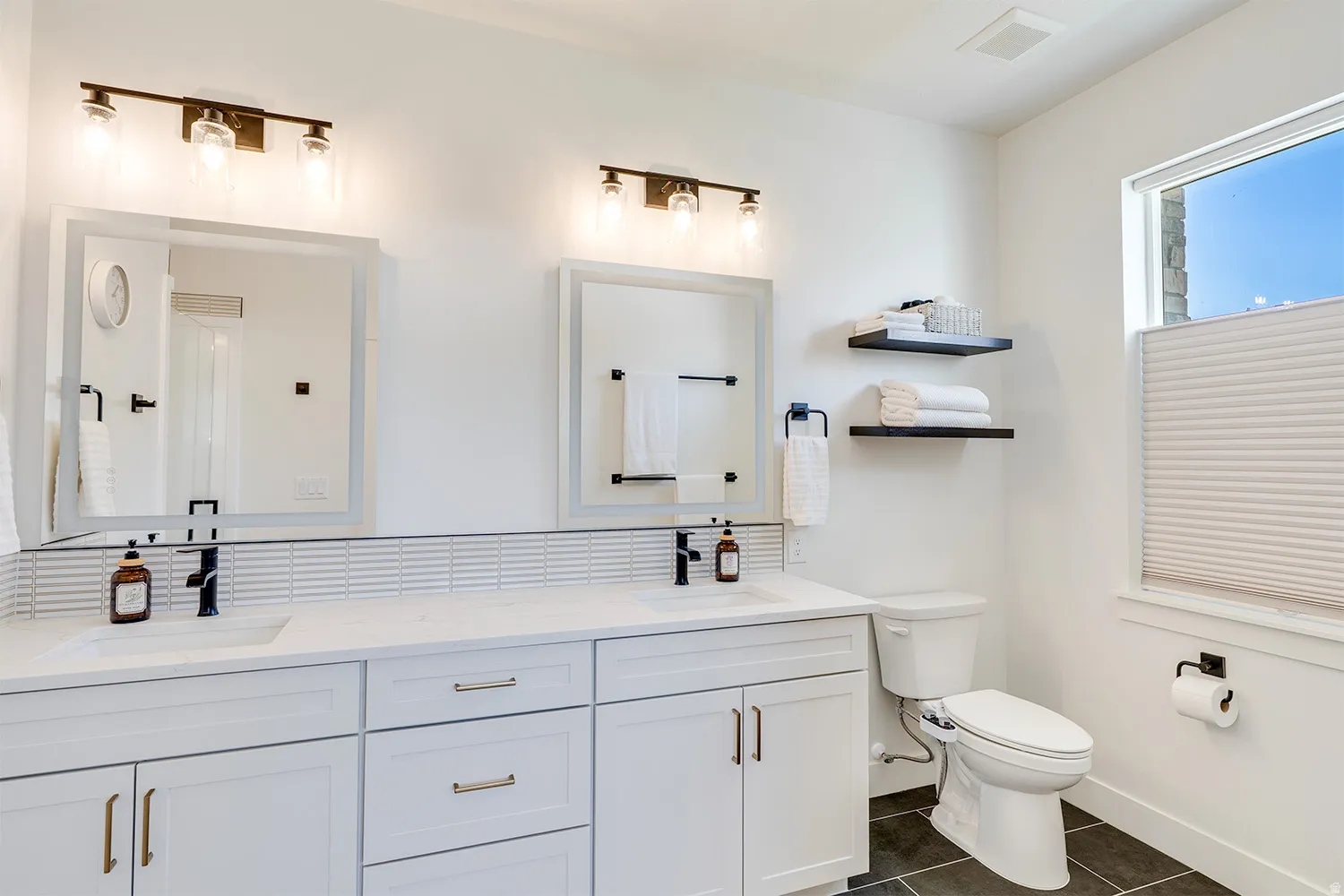 Dual vanity featuring white shaker cabinetry, quartz countertops, and matte black hardware