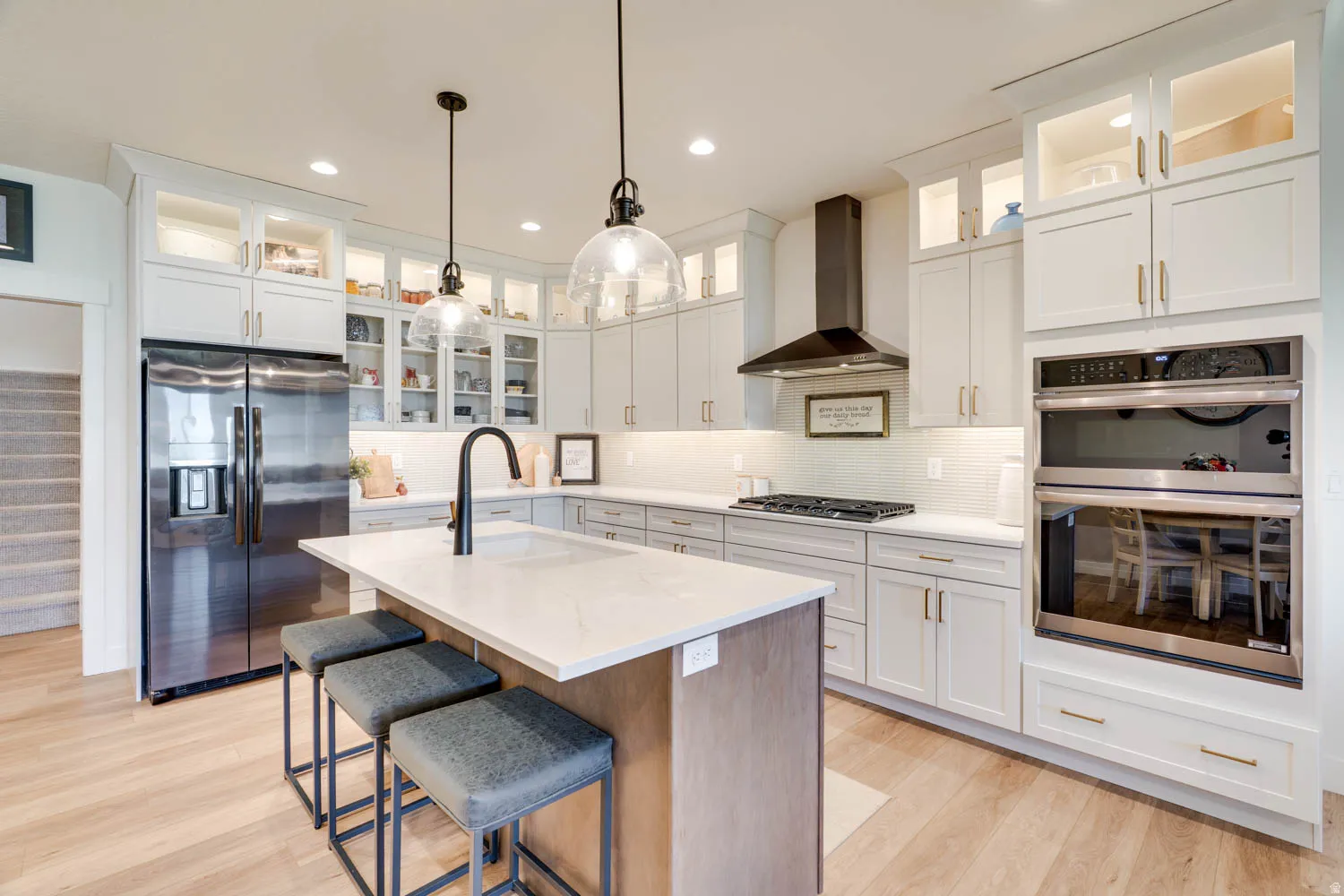 Modern kitchen featuring light wood-finish flooring and an expansive center island with a light-toned countertop