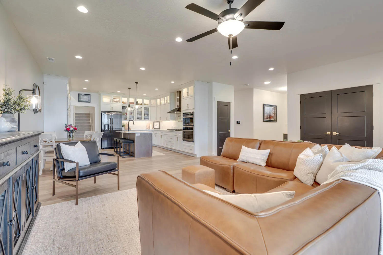 Open-concept living area with wood-finish flooring, recessed lighting, and a ceiling fan