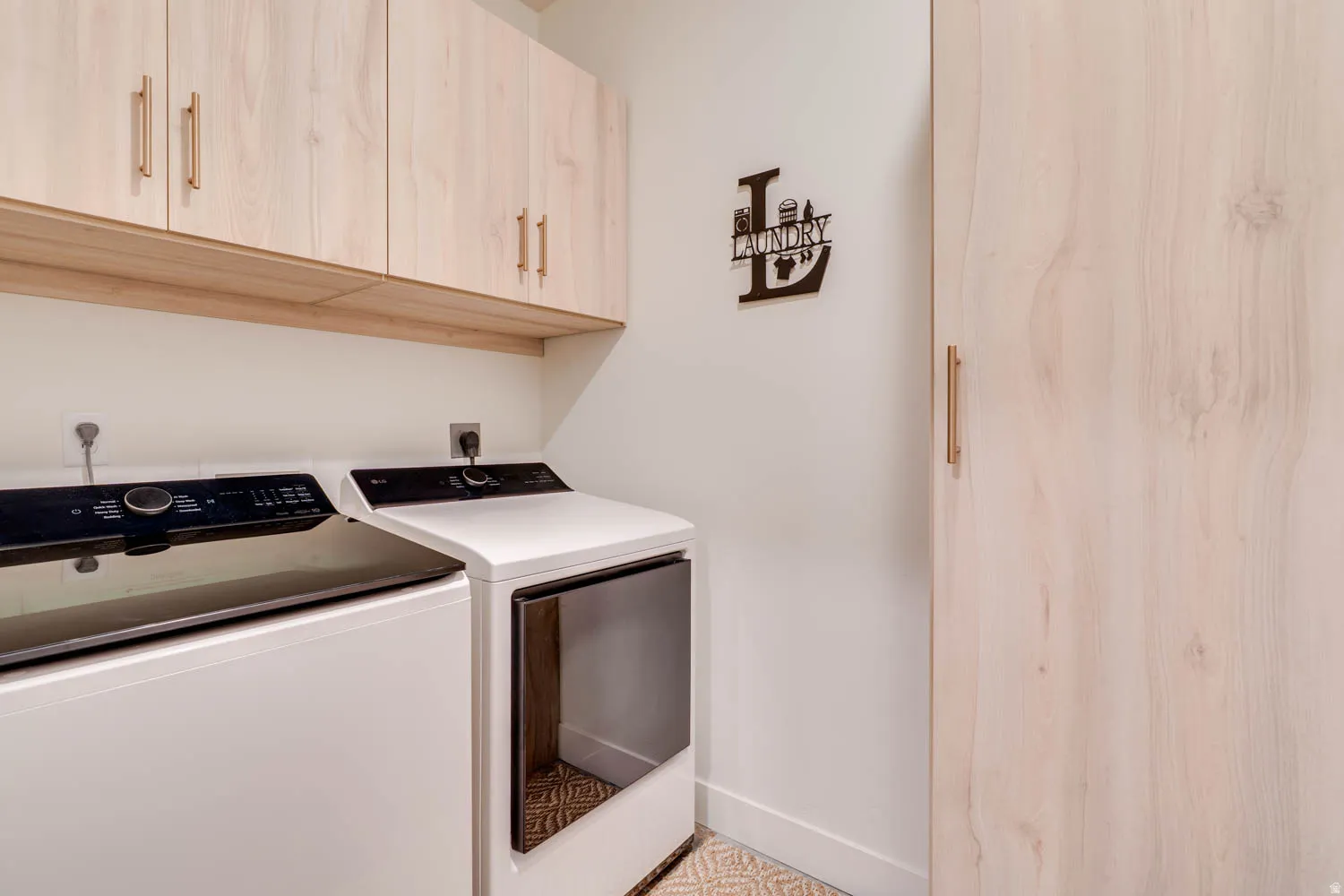 Laundry area featuring wood-finish cabinetry with linear hardware