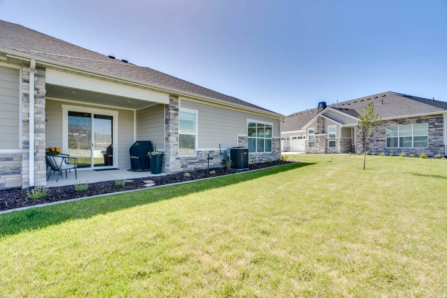 Rear exterior featuring a covered concrete patio with sliding glass door access