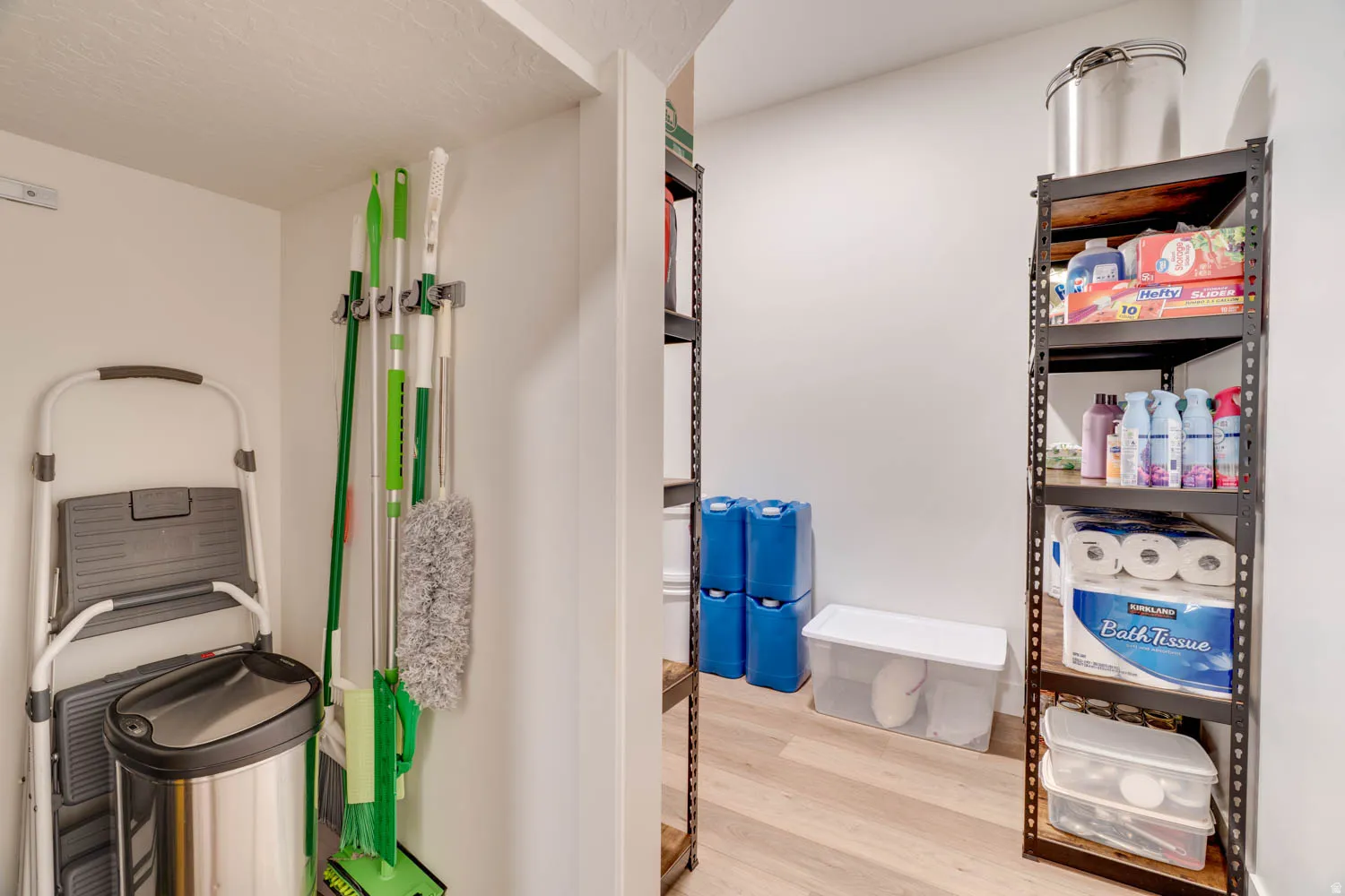Dedicated storage area featuring robust metal shelving units and durable wood-finish flooring