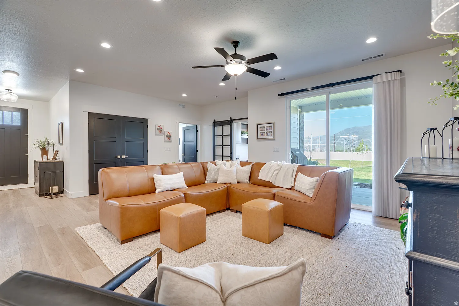 Open-concept living space featuring wood-finish flooring, recessed lighting, and a ceiling fan