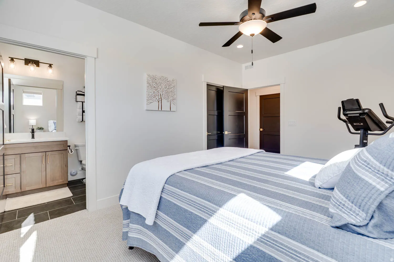 Recessed lighting and a ceiling fan fixture illuminate the room