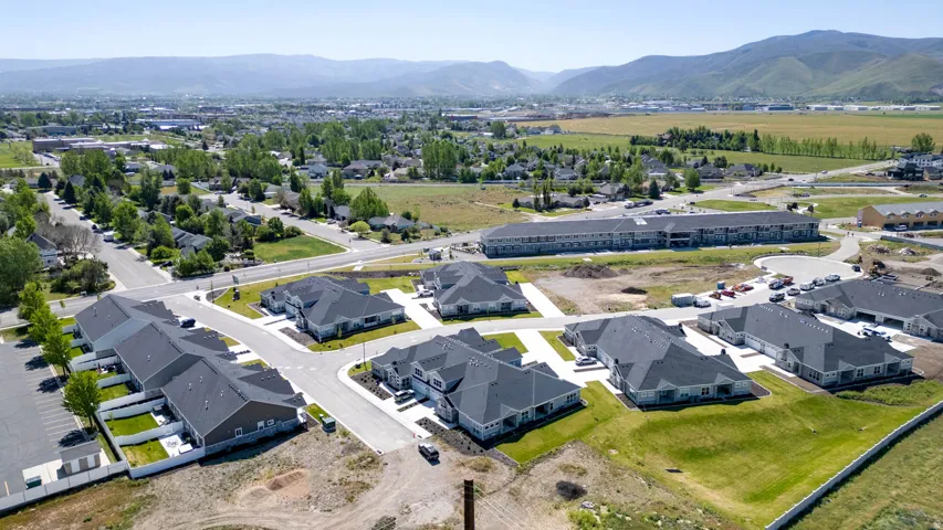 Community of residences featuring single-story homes with dark shingle roofs and light-colored siding