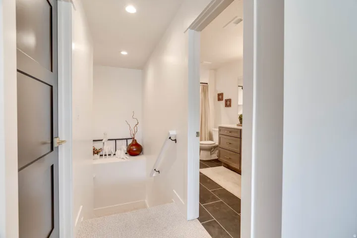 Hallway with recessed lighting and light-toned flooring