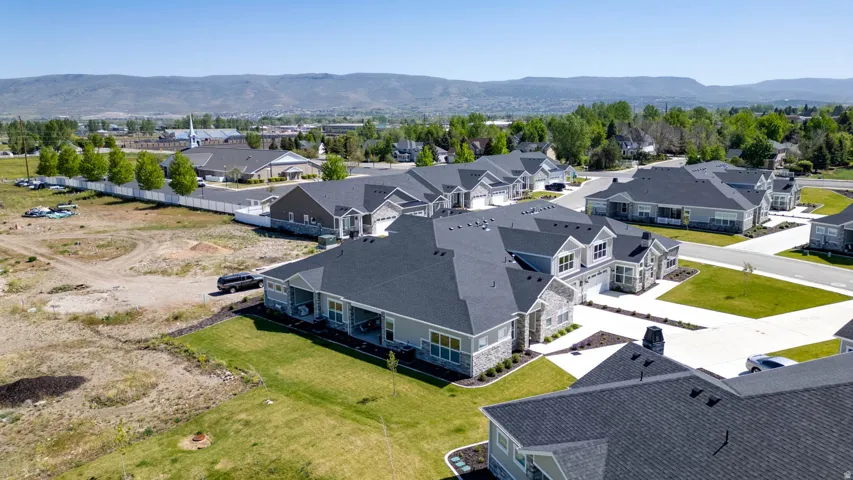 Contemporary single-story residence featuring a dark shingle roof, light-colored siding, and stone veneer accents