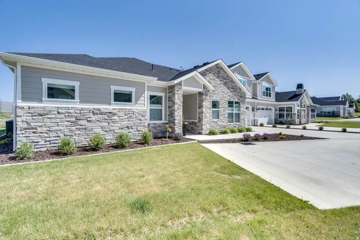 Contemporary exterior featuring light gray horizontal siding and a stacked stone facade